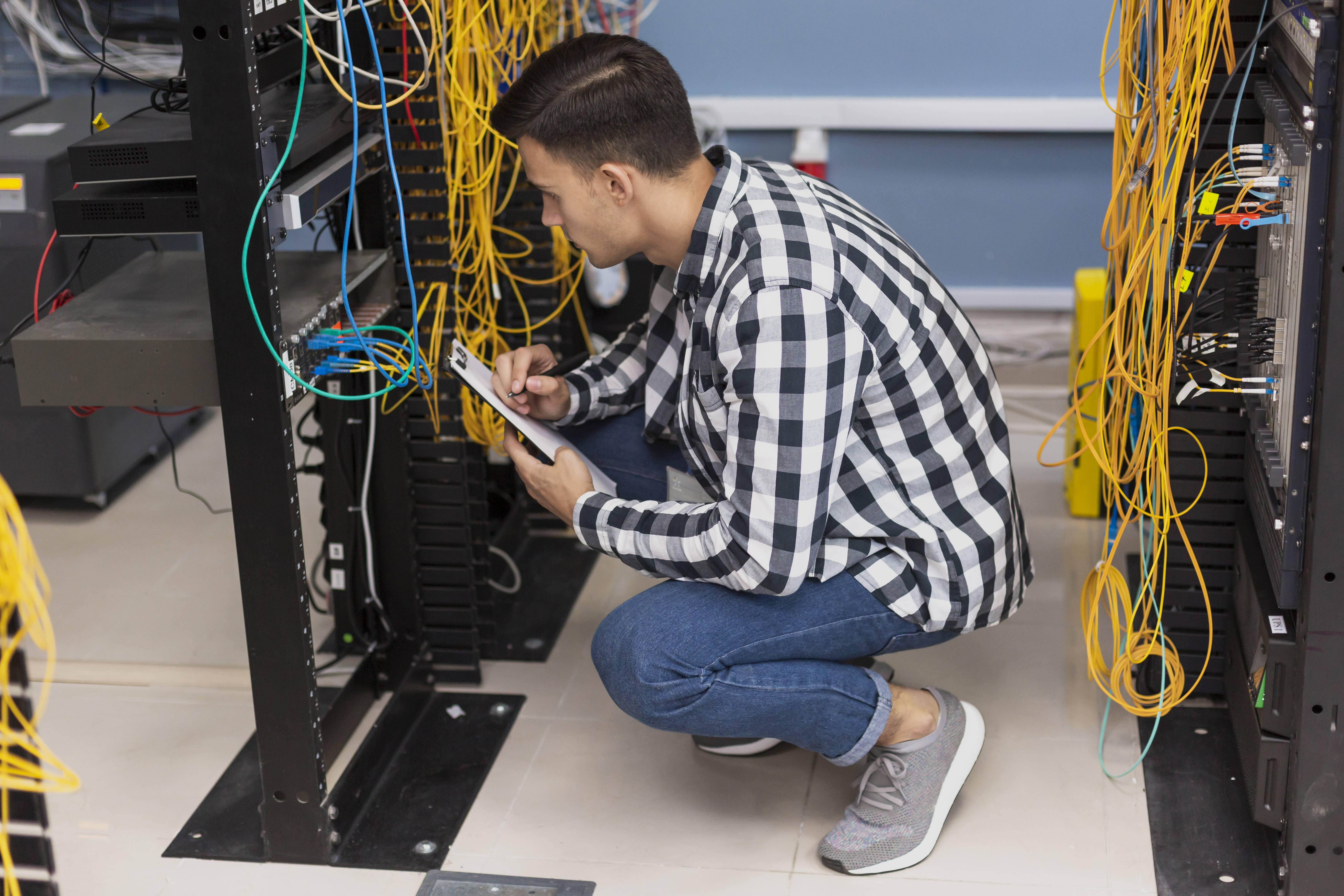 Young engineer working in server room